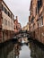 Boats in a narrow canal, enclosed by towering buildings in Venice,Italy
