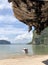 The boats are parked on a deserted clean beach against the backdrop of hanging unique rocks of the island of Thailand on a clear