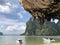 The boats are parked on a deserted clean beach against the backdrop of hanging unique rocks of the island of Thailand on a clear