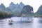 Boats and rafts on Li-River or Li Jiang, China with bizarre limestone mountains