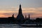 Boats sail on the Chao Phraya river in the late evening. Wat Arun Temple stands on the river