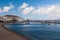 Boats at sea port in mykonos, greece. Church and houses in fishing village with nice architecture. Sea beach on blue sky