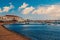 Boats at sea port in mykonos, greece. Church and houses in fishing village with nice architecture. Sea beach on blue sky