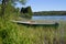 Boats at the shore of a forest lake, standing in the grass