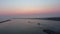 Boats slowly leaving the harbor and sailing into the horizon in peaceful ocean.