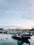 Boats stand at the pier against the backdrop of buildings at sunset