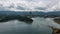 Boats surrounded by a majestic mountain range in the background under a cloudy sky in Guatape