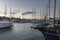 Boats in Vlichada harbor on Santorini island in Greece in the morning at sunrise. The background is a blue sky with white clouds