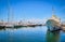 Boats and yachts anchored or moored in Athens marina and by its promenade in Glyfada on a bright summer day. Athens