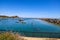 Boats and yachts docked in the deep blue ocean water of the Dana Point Harbor with people and colorful paddle boards