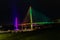 Bob Kerrey pedestrian bridge Omaha Nebraska at night with purple, yellow and green lights reflections in Missouri river.