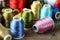 Bobbin with colorful threads on a wooden background