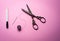 Bobbin or spool of thread and scissors with needle for sewing on pink background , hobbies and pastimes , minimalist image