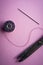 Bobbin or spool of thread and scissors with needle for sewing on pink background , hobbies and pastimes , minimalist image