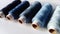 Bobbins of thread in different shades of blue. Spools of thread located on a white background