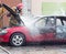 BOBRUISK, BELARUS - JULY 25, 2018: Two firemen extinguish a burning car, fire