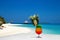 Bocal of fruity cocktail on a beach table. Maldives Island landscape. Tropical fresh juices on white sandy beach. Colorful fruity