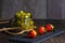 Bodegon fruit, fresh strawberries on slate plate with glass jar with fresh grapes on aged basis
