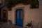 BODRUM, TURKEY: Typical Mediterranean village scene in whitewashed walls and blue door framed by lush greenery.