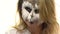 Body art owl in a girl on her face, who looks coquettishly at her friend. Animal Make up