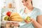 Body Care. Chubby girl standing in kitchen with fruit plate close-up blurred background smiling cheerful