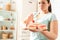 Body Care. Chubby girl standing in kitchen holding plate with desserts reject temptation close-up blurred background