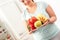 Body Care. Chubby girl standing in kitchen with plate of fruits and vegetables close-up smiling happy blurred
