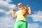 Body care and healthcare. Elderly man practicing sports on blue sky background. Happy senior man with dumbbell looking