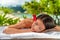 Body care massage at outside spa on beach at luxury vacation resort. Asian beauty woman relaxing sleeping lying on table