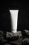 Body cream lotion bottle luxury packaging tube with stone rock concrete grunge on dark black background, aroma spa smell treatment