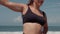 Body positive woman is training on ocean coast