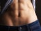 Body with press cubes, strong elastic belly. Fashion jeans and t-shirt, close up