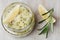 Body scrub of sea salt with lemon, rosemary and olive oil in glass jar on stone table