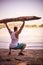 Bodybuilder on the beach picks up a tree.