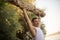 Bodybuilder on the beach picks up a tree and exercises