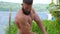 Bodybuilder demonstrates muscles. Young bearded athletic bodybuilder plays sports outdoors