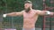 Bodybuilder demonstrates muscles. Young bearded athletic bodybuilder plays sports outdoors