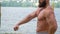 Bodybuilder demonstrates muscles. Young bearded athletic bodybuilder plays sports outdoors