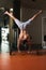 Bodybuilder Exercising Handstand Push-Ups On Barbell In Gym