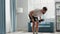 Bodybuilder practices triceps kick-backs with dumbbells