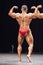 Bodybuilder shows his back double biceps pose on stage