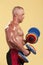 Bodybuilder training with dumbbells