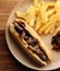 Boerewors roll with chips and braised onion
