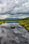 Bog and mountains showing as reflections on a small calm bog