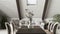 Bohemian dining table close up, living room in boho style with sofa in dark wooden mezzanine with gabled ceiling. Potted plants