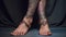 Bohemian woman bare feet on black background with tattoos