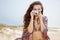 Bohemian woman taking photos with retro photo camera on beach