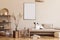 Boho composition of living room with furnitures, mock up painting, rattan decoration, bamboo shelf with elegant personal.
