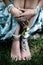 Boho fashion details woman hands and bare feet on grass with lot