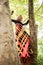 Boho girl in long colorful dress stand on tree in park summer da